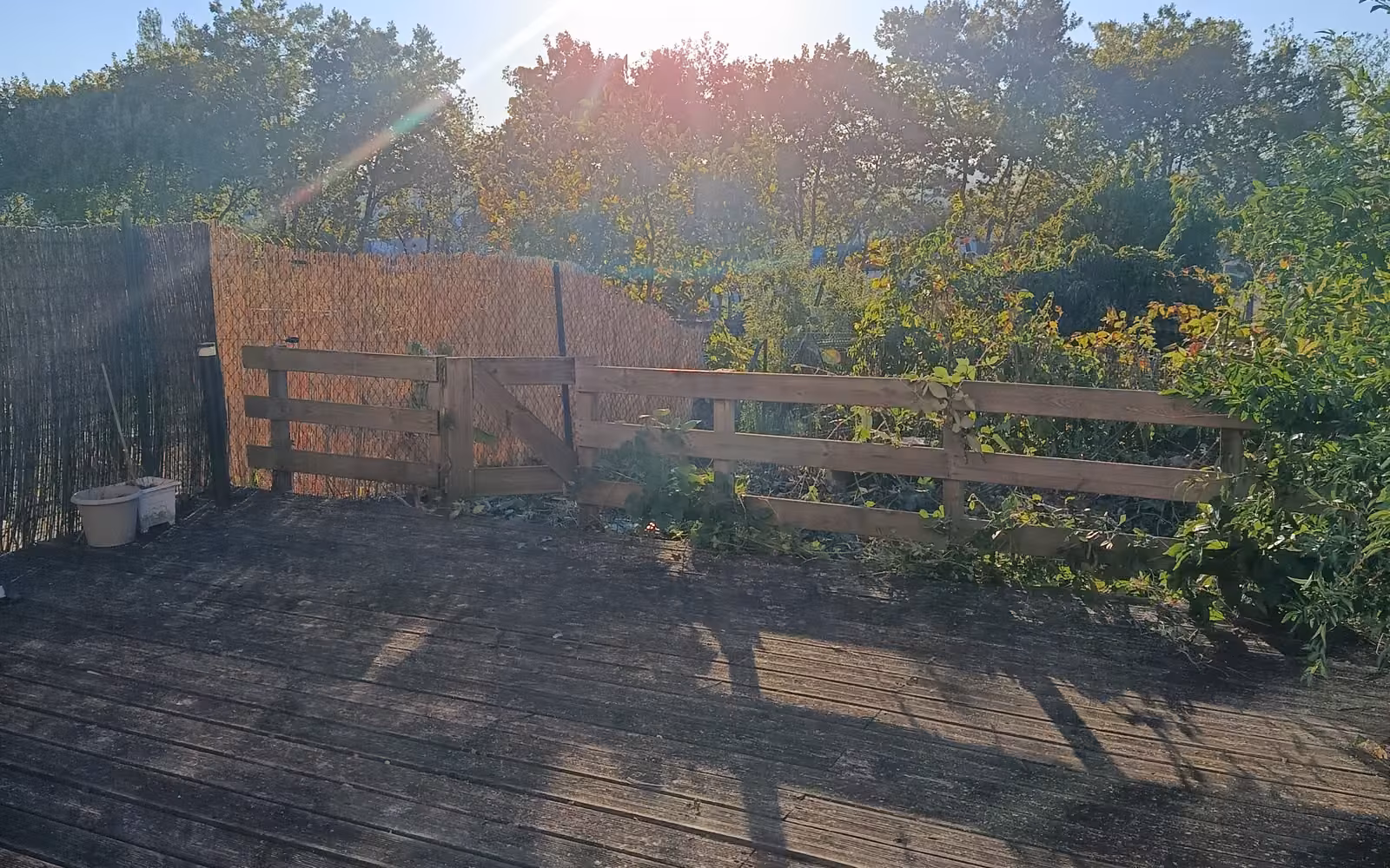 Terrasse dégagée avec clôture bois, grillage et canisse neufs, vue ouverte sur les jardins